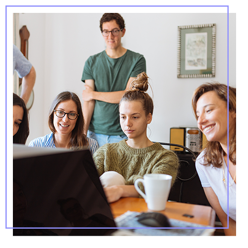 junge Erwachsene sitzen am Tisch, arbeiten am PC an der Steuererklärung